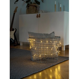 Konstsmide Micro LED Lichterkette mit 100 bernsteinfarbenen LEDs und transparentem Kabel im Innenbereich.