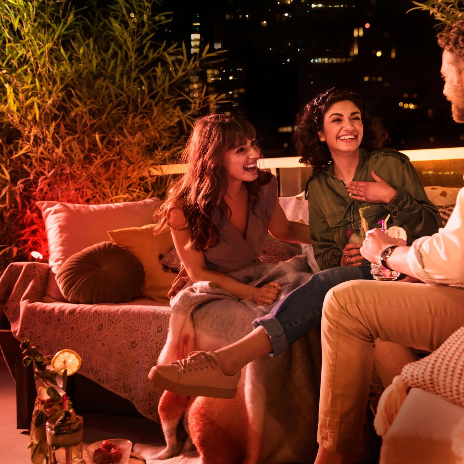 Szene mit Philips Hue Lily LED-Spots: Freunde genießen farbiges Licht im Garten.