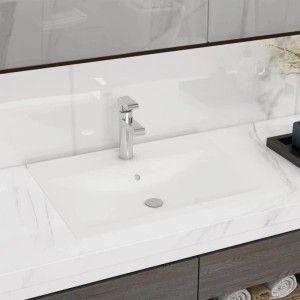 Matt-weißes, rechteckiges Keramik-Waschbecken mit Chrom-Armatur, integriert in eine weiße Arbeitsplatte im modernen Bad.