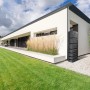 Anthrazitfarbene Waterform Regentonne Tower Stone (350 l) vor modernem Haus mit Garten.