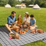 Familie beim Picknick auf karierter, wasserdichter Sekey Picknickdecke (200x200cm, grau) im Grünen.