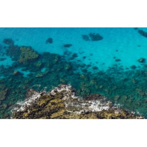 Sanders Fototapete: Küstenlandschaft mit hellblauem, türkisfarbenem Meer und Felsen.