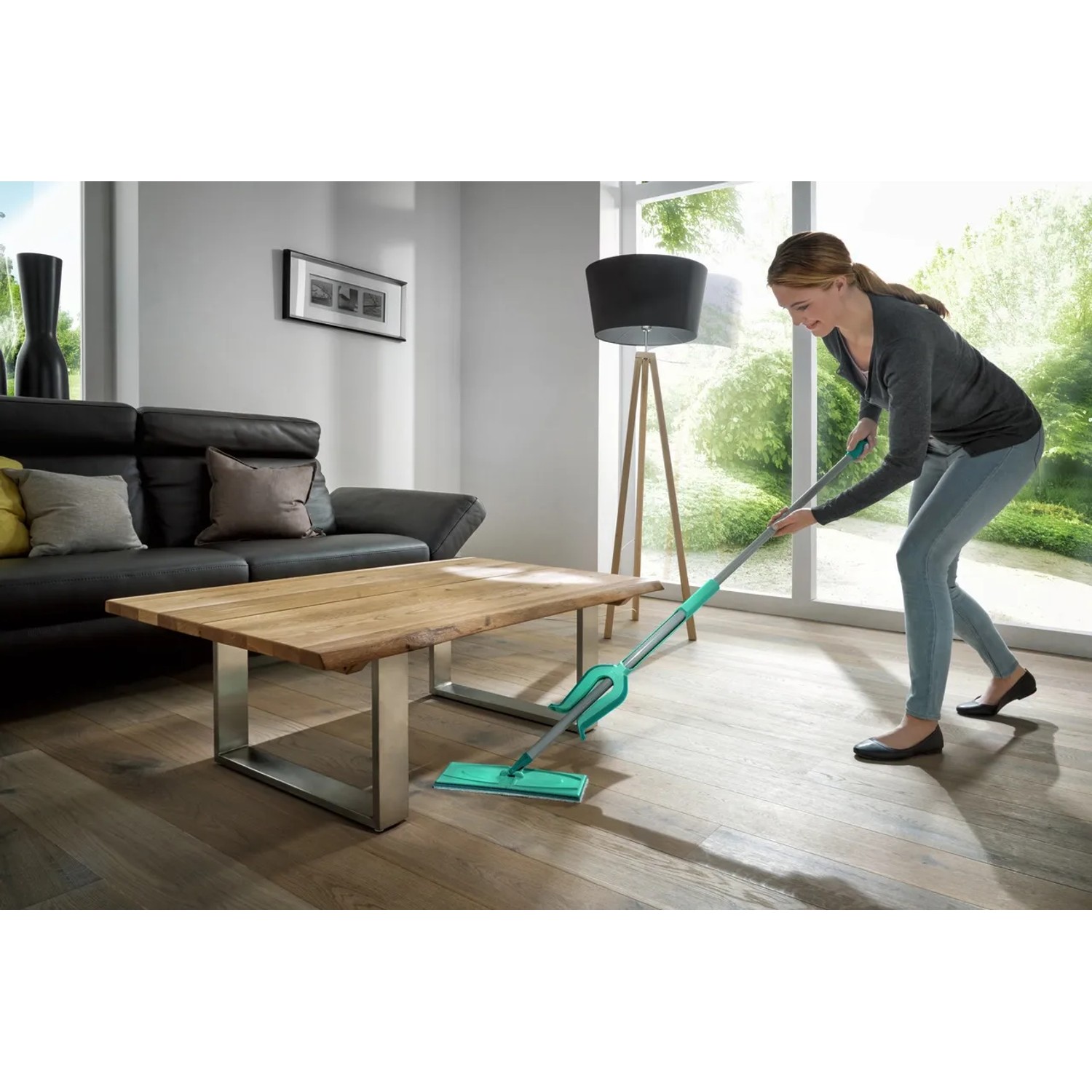 Frau wischt Boden mit Leifheit Picobello XL Bodenwischer in modernem Wohnzimmer.