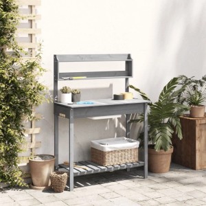 Grauer Pflanztisch aus Tannenholz mit Waschbecken, zwei Ablagen und Haken auf gepflasterter Terrasse. Ideal für Gartenarbeiten.