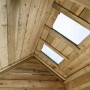 Innenansicht SwingKing Spielhaus Louise: Holzwände, Dach mit zwei Plexiglas-Fenstern.