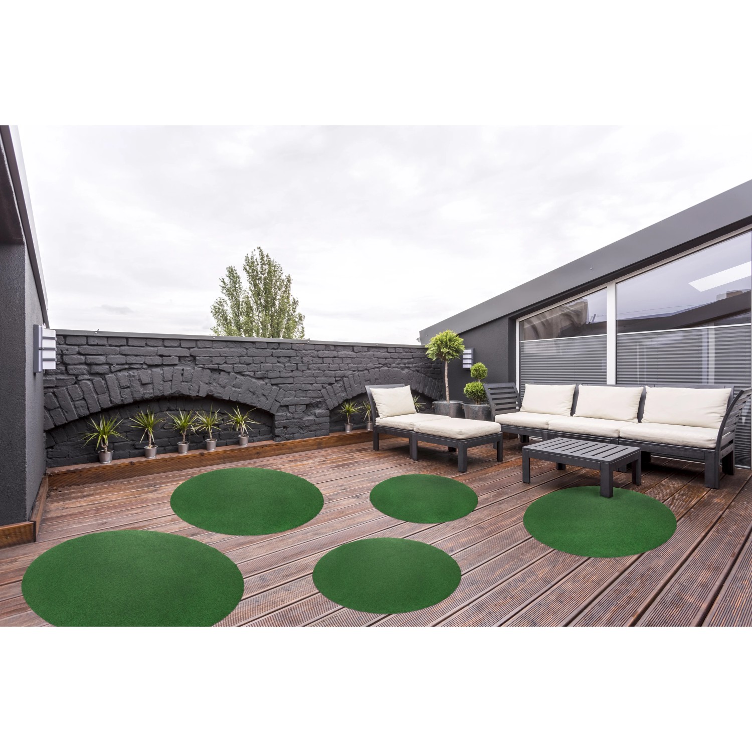 Andiamo Kunstrasen, runde grüne Teppiche auf einer Terrasse mit Gartenmöbeln.