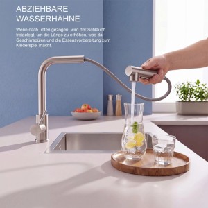 Edelstahl Küchenarmatur mit Ausziehbrause füllt Wasserkaraffe am Spülbecken. Moderner Einhebelmischer für die Küche.