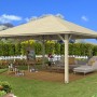 Unbehandelter Skan Holz Pavillon Cannes 4, 489x489 cm, im Garten mit Lounge-Möbeln und Staffelei.