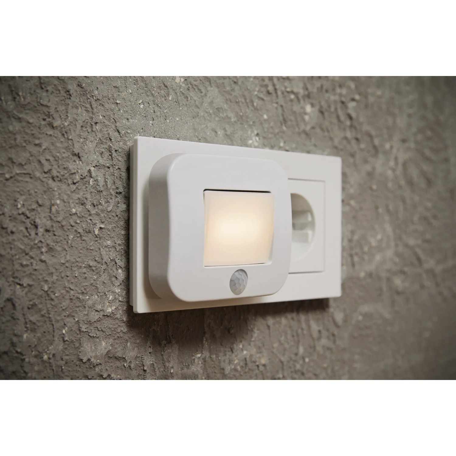 Weißes Ledvance LED-Nachtlicht Lunetta Hall mit Sensor in Steckdose an Wand.