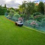 Grauer Segway Navimow Mähroboter i105E ohne Begrenzungskabel im Garten.