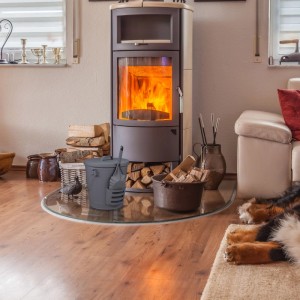 Grauer Relaxdays Ascheeimer aus Stahl, 19 l, mit Deckel und Schaufel neben einem Kamin. Ideal für Kaminzubehör.