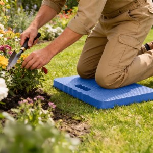 Person kniet auf blauem EVA-Kniekissen im Garten, pflegt Pflanzen. Knieschutz für Outdoor-Arbeiten.