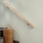 Montierter, roher Fichte Handlauf (1500mm) mit Befestigungsmaterial an einer Wand neben einer Treppe.