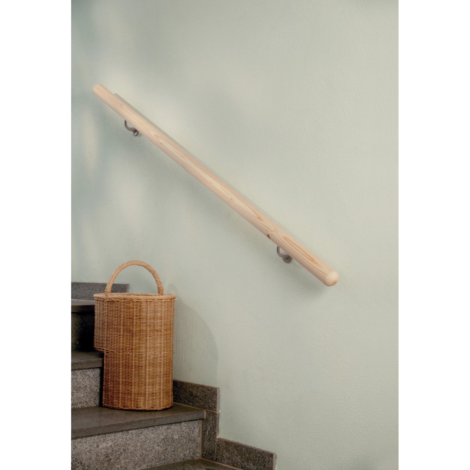Montierter, roher Fichte Handlauf (1500mm) mit Befestigungsmaterial an einer Wand neben einer Treppe.