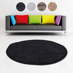 Schwarzer, runder Bestlivings Leder Flickenteppich (Ø 150 cm) vor Sofa mit Kissen.
