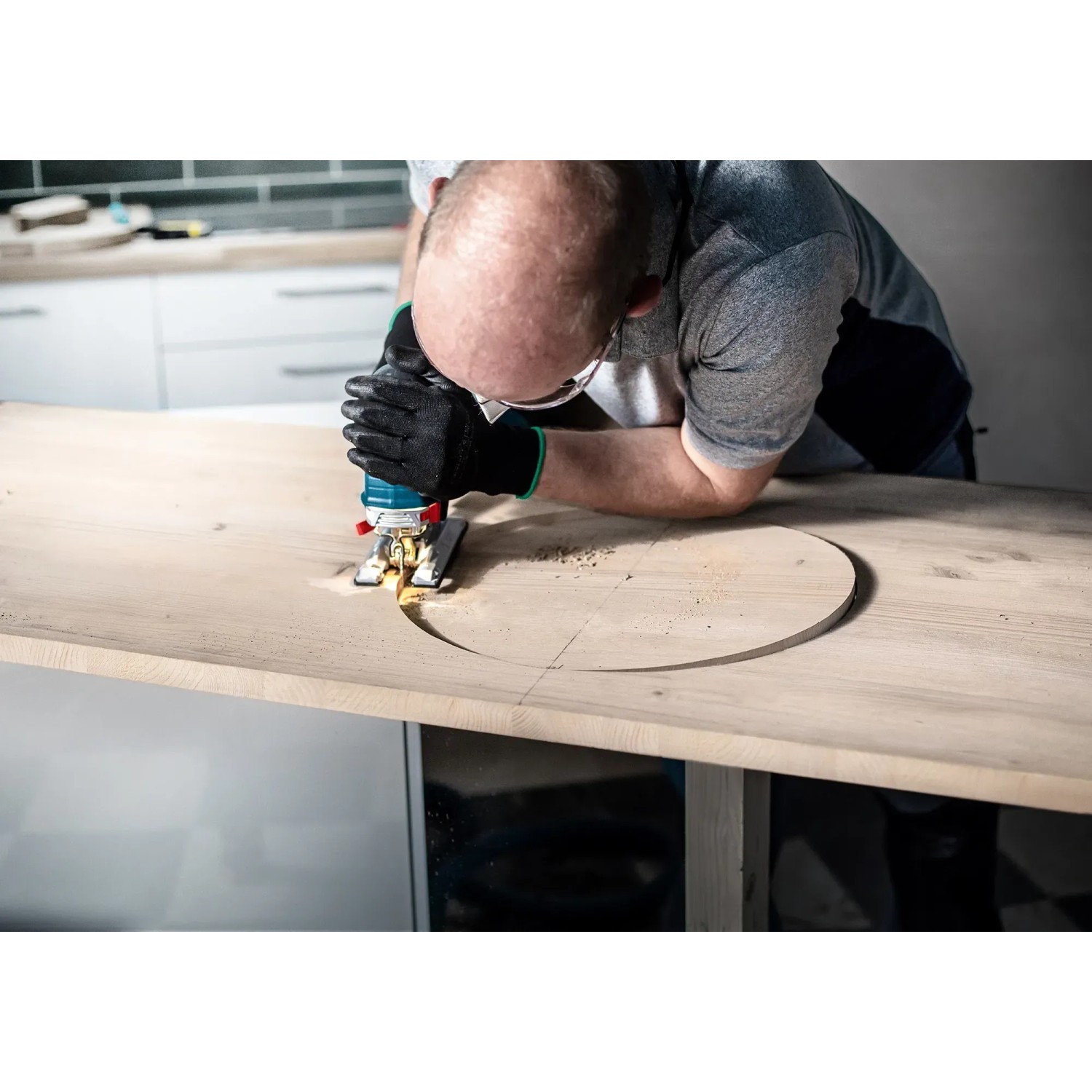 Mann sägt mit Bosch Stichsägeblatt T308BO ein Loch in ein Holzbrett.