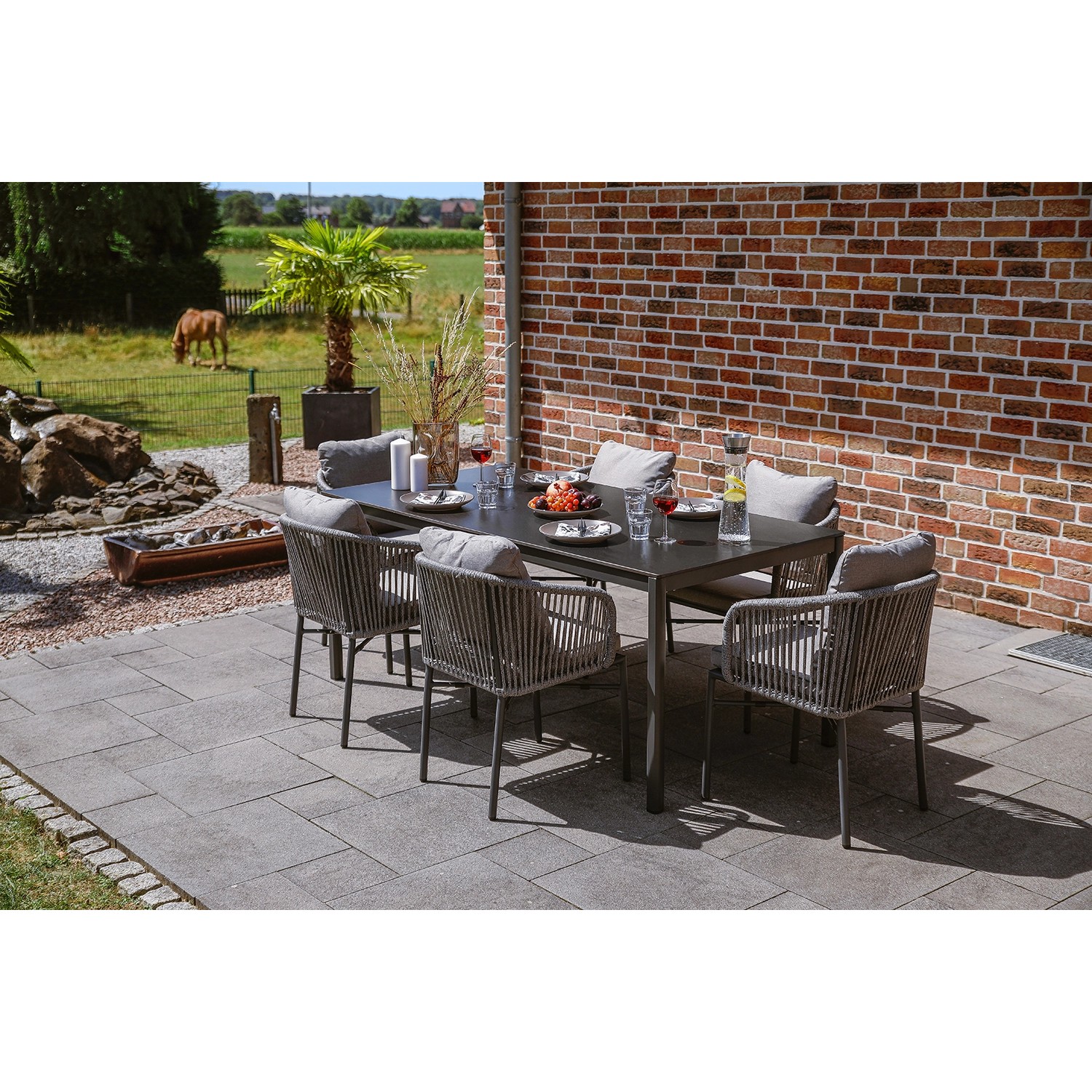 Greemotion Gartenmöbel-Set Calgary 1, 7-teilig, anthrazitfarben mit Tisch und Stühlen mit grauen Auflagen.