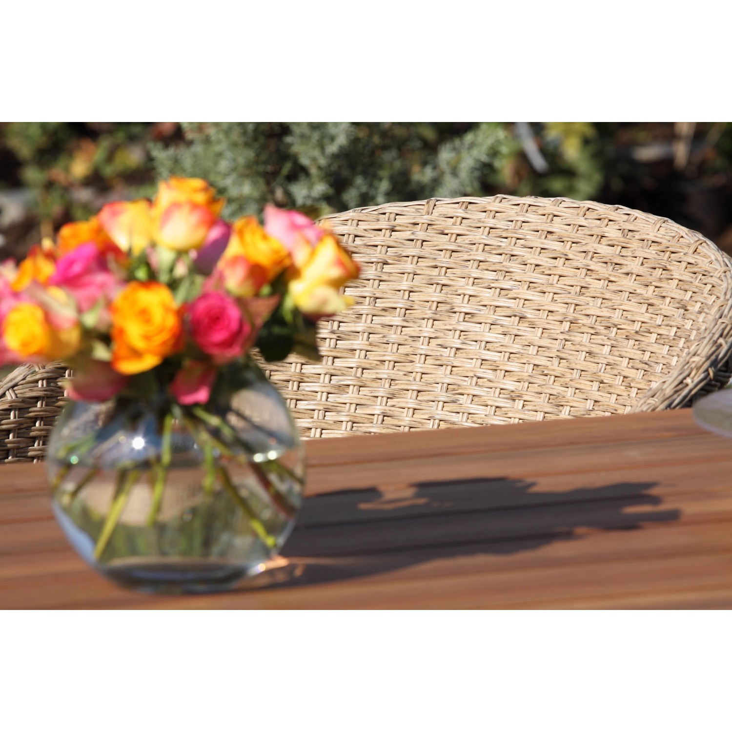 Acamp Atacama Gartenstuhl: Detailansicht von Geflecht und Teakholz mit Blumenvase.