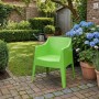 Grüner DELUKE Gartenstuhl HENRI aus Kunststoff auf Terrasse. Stapelbarer Loungestuhl für Outdoor-Momente.