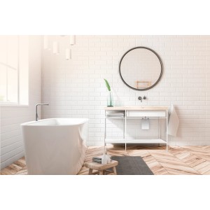 Modernes Badezimmer mit Badewanne und Waschtisch. Runder Spiegel an weißer Wand.