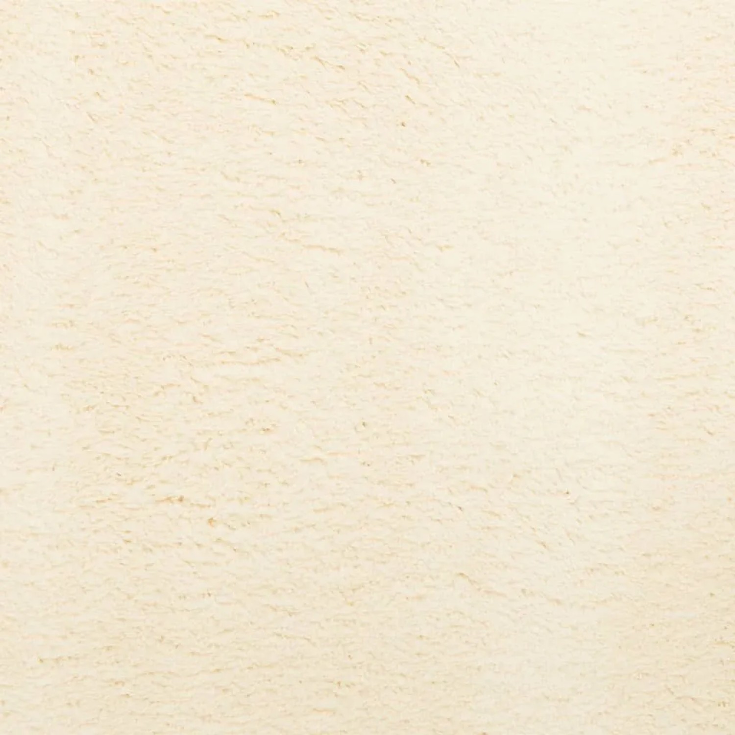 Nahaufnahme des cremefarbenen, weichen Kurzflor-Teppichs HUARTE. Flauschige Textur.