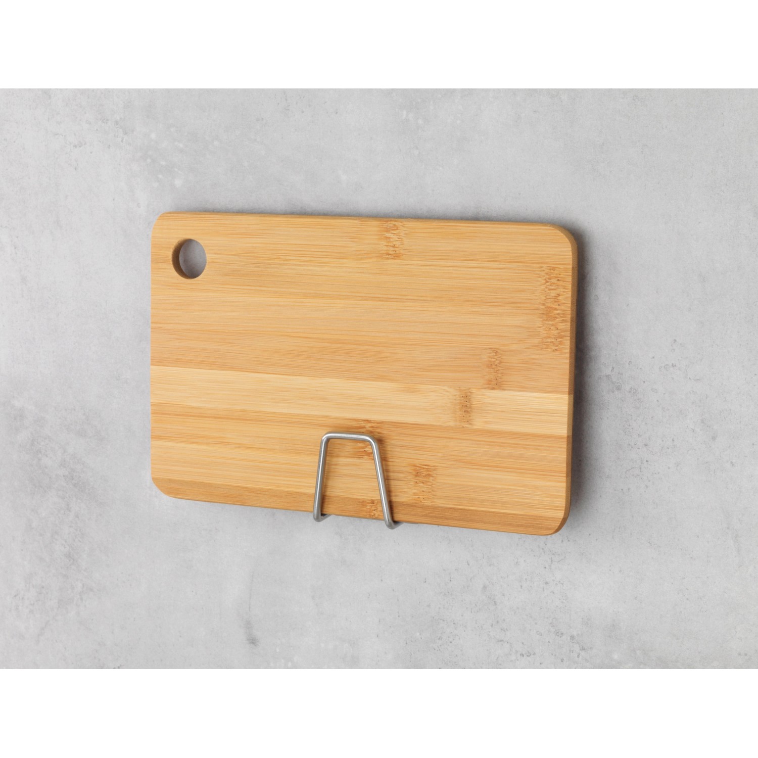 Wenko Universal-Halter Edea aus Edelstahl mit Schneidebrett an grauer Wand.