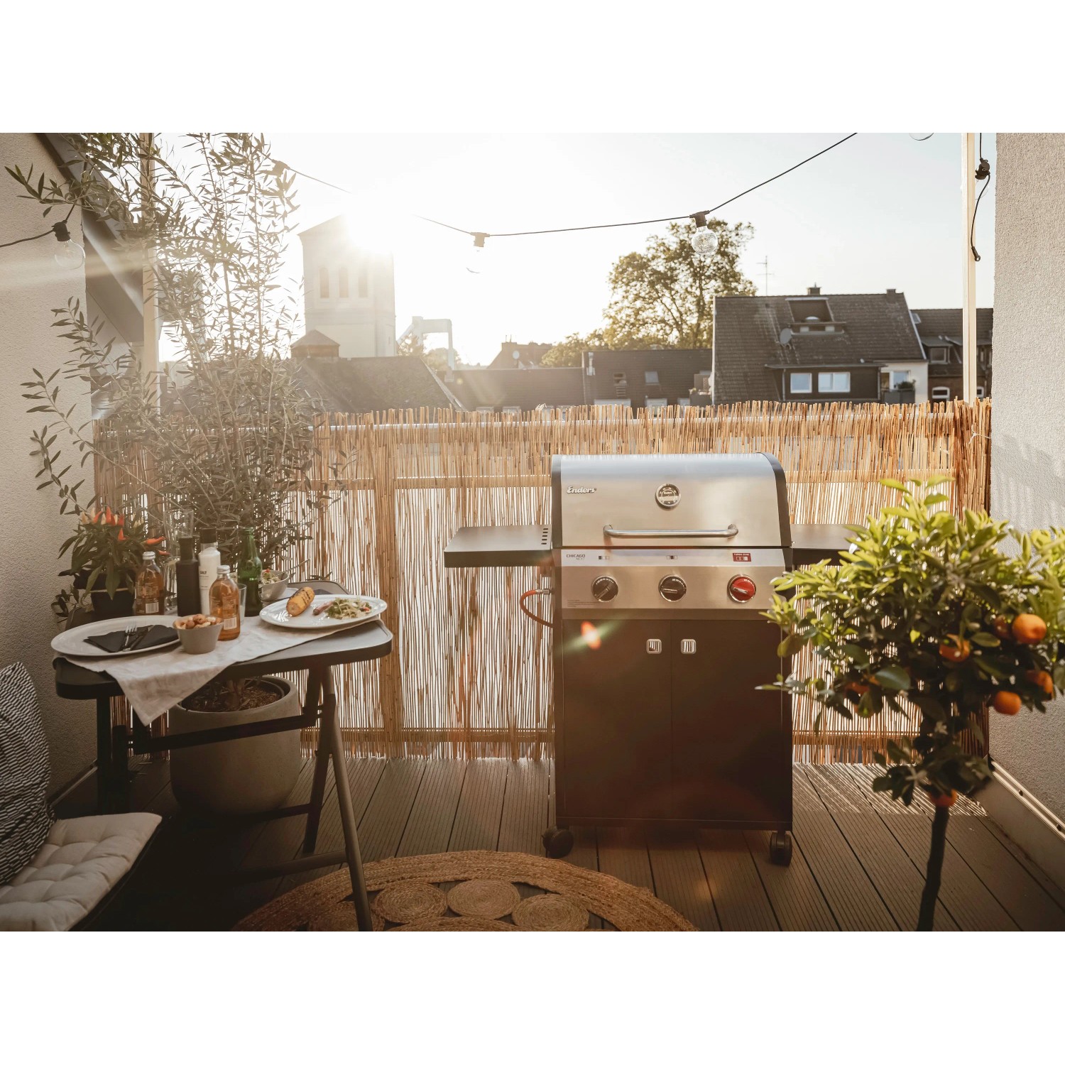 Enders Gasgrill Chicago Next 3 mit 3 Brennern auf Balkon mit Tisch und Deko.