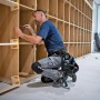 Handwerker mit Bosch Professional Werkzeuggürtel und Werkzeugtaschen bei Montagearbeiten.