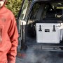 Sandfarbene Petromax Kühlbox 25l im Kofferraum, ideal für Camping und Outdoor-Abenteuer.