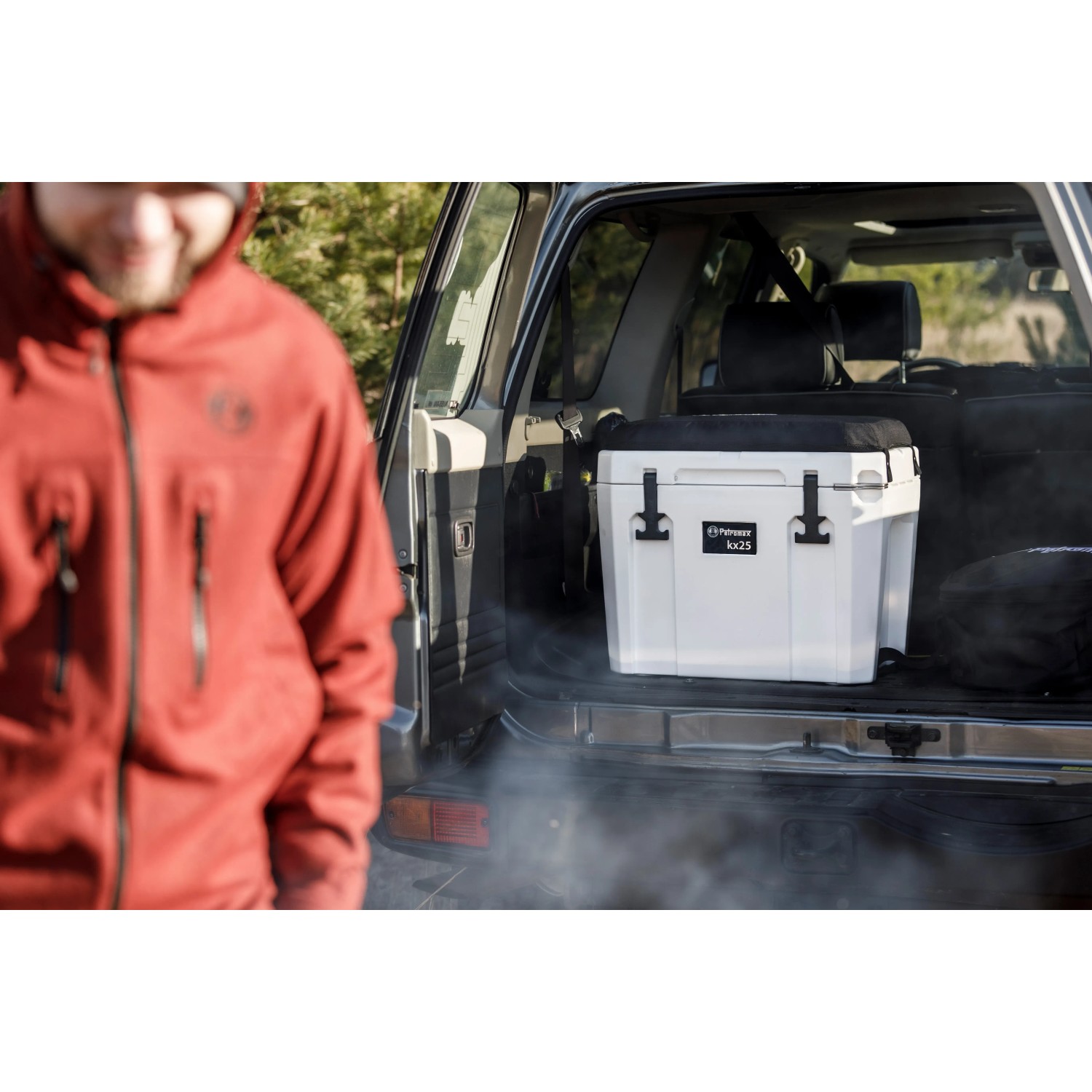 Sandfarbene Petromax Kühlbox 25l im Kofferraum, ideal für Camping und Outdoor-Abenteuer.