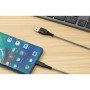 Schwarzes USB-Ladekabel (USB-A auf USB-C) mit Smartphone und Tastatur im Hintergrund.