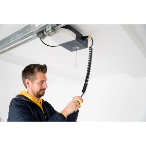 Schellenberg Spiralkabel am Garagentorantrieb Smart Drive L/XL mit Mann, der Stecker hält.