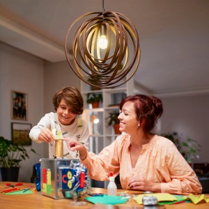 Philips LED-Lampe E27, 4W, klare Glühlampenform, in Wohnraum mit Kind.