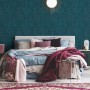 Schlafzimmer mit blauer Vliestapete Trendwall 2 Uni Glänzend FSC® an der Wand.