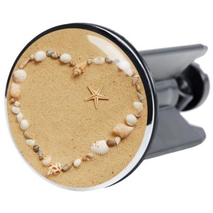 Sanilo Waschbeckenstöpsel Seashells mit Herz aus Muscheln und Seestern auf Sand.