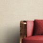 Beige Vliestapete Zeno mit Textilstruktur und rotem Sofa im modernen Wohnraum.