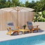 Zwei graue Adirondack-Auflagen auf Holzstühlen am Pool, mit Sonnenschirm und Holzzaun.