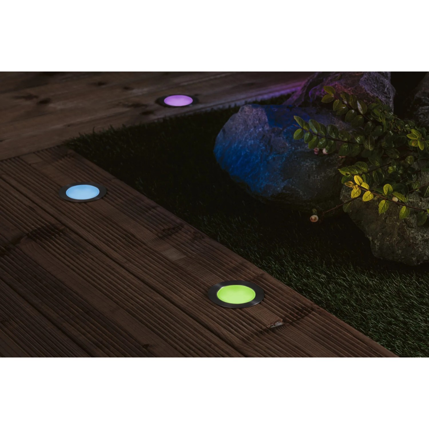 Paulmann Plug & Shine LED-Bodeneinbauleuchten mit RGBW-Funktion auf einer Holzterrasse.