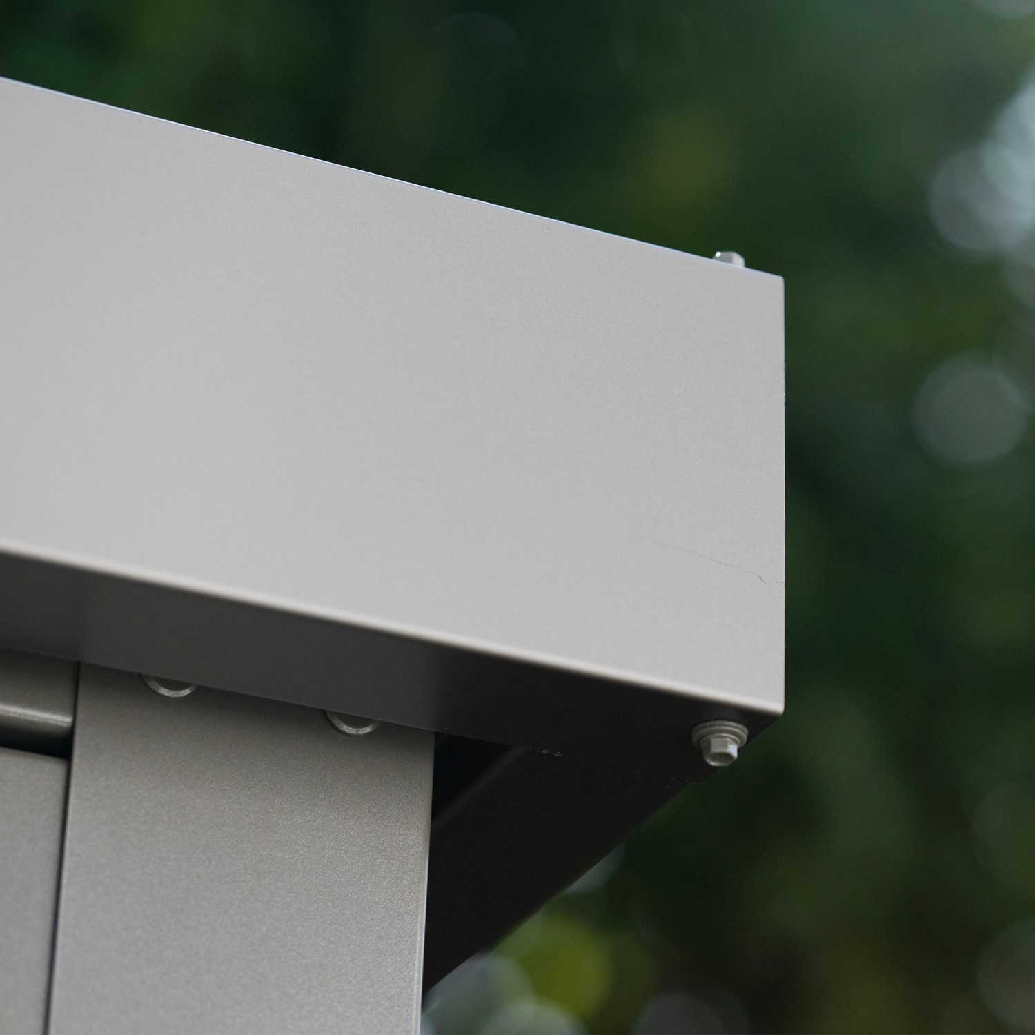 Detailaufnahme: Graues Amazing Spaces Gartenhaus Shape, Metalleck mit Schraube.