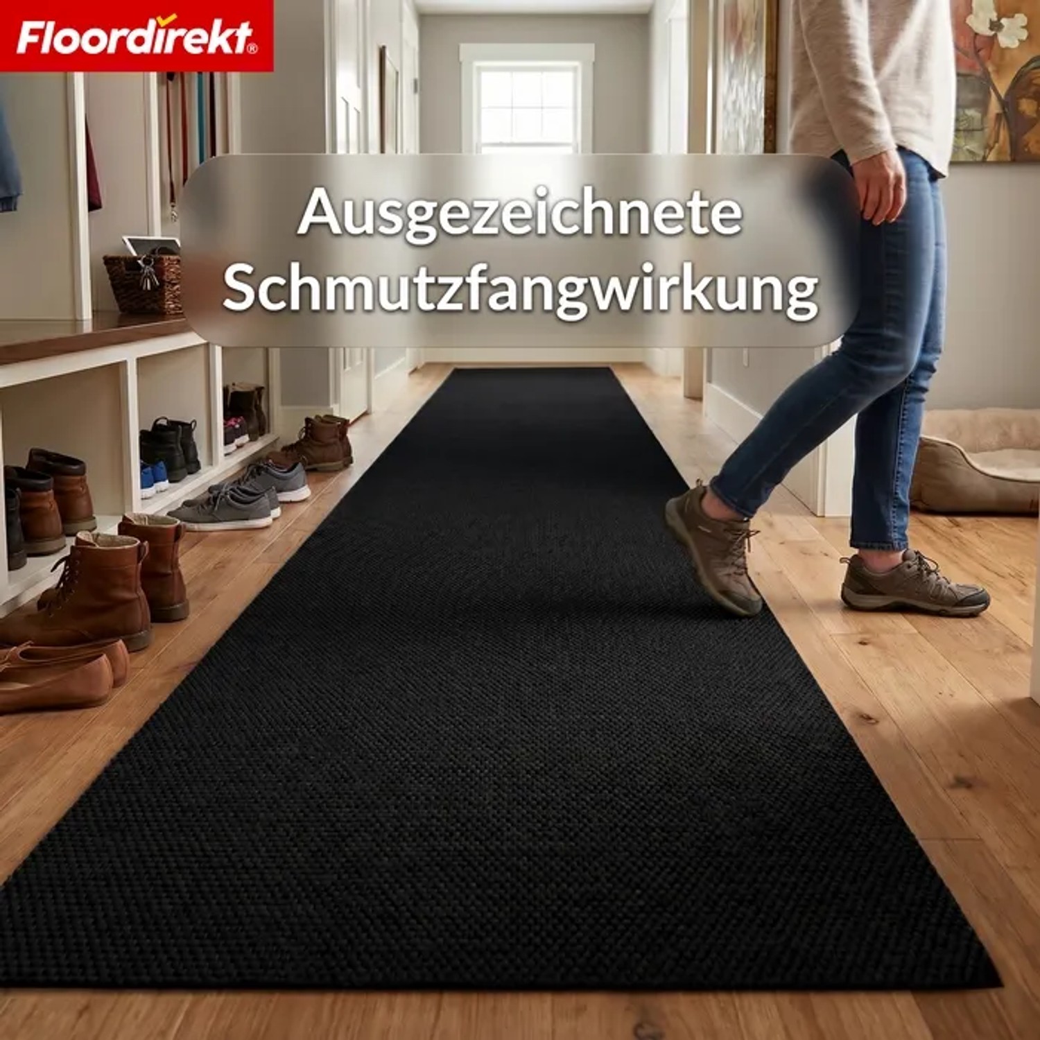 Lange schwarze Floordirekt Schmutzfangmatte Hong Kong PRO im Flur, eine Person geht darauf. Robuste Fußmatte für Eingangsbereiche.