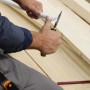 Fiskars Hochleistungsmesser schneidet Kunststoffrohr, Holster sichtbar.