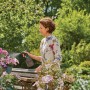 Frau benutzt Gardena Pumpsprüher 0,75 l zum Besprühen von Blumen.