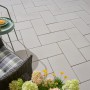 Verlegte Kann Platte Vero silbergrau 60x30 cm auf Terrasse mit Stuhl und Tisch.