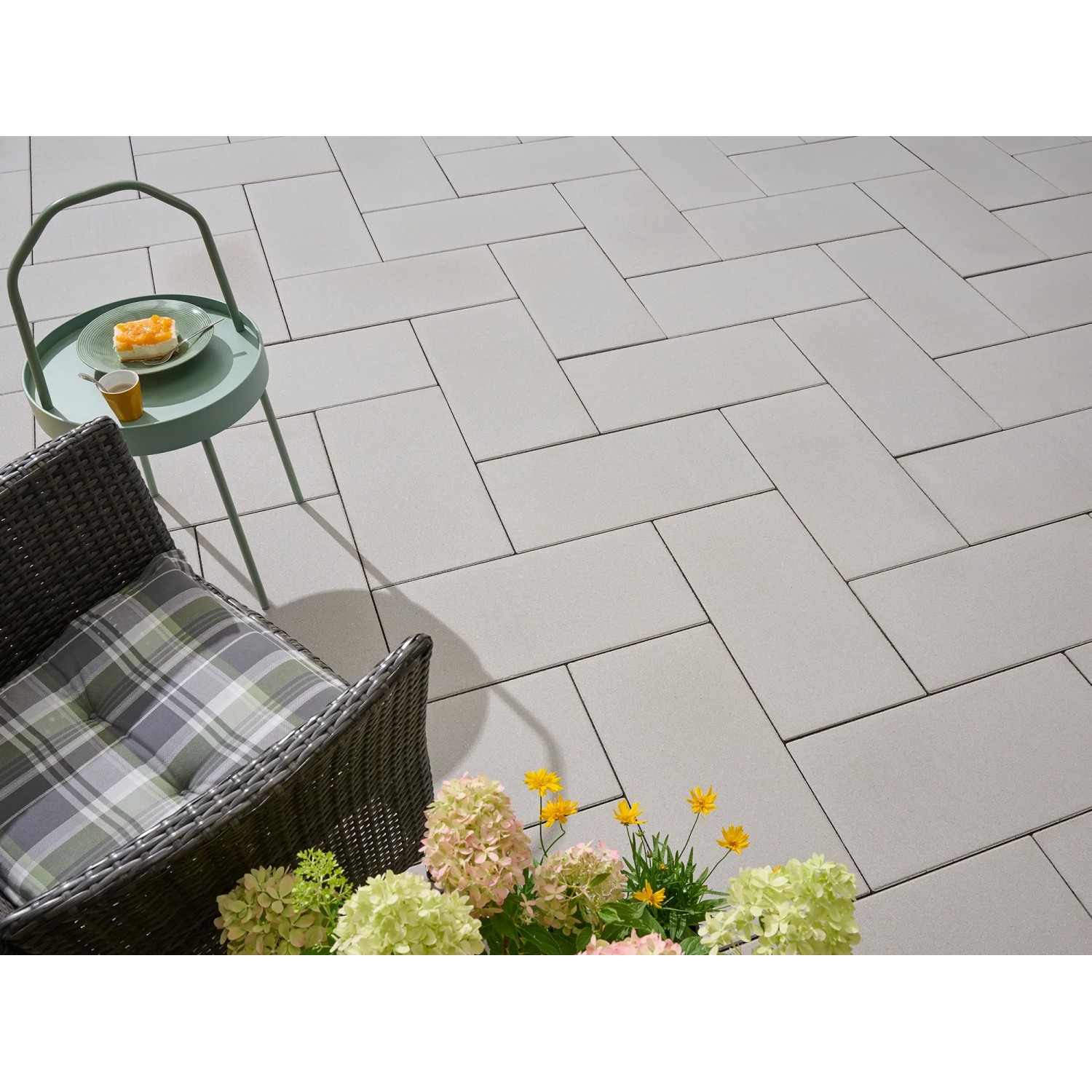Verlegte Kann Platte Vero silbergrau 60x30 cm auf Terrasse mit Stuhl und Tisch.