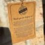 Detailaufnahme eines Anhängers mit dem Text "Thank you for buying me!" und dem Hinweis auf Handarbeit.