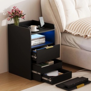 Schwarzer Nachttisch mit blauer LED-Beleuchtung, zwei Schubladen, offener Ablage und Ladestation neben einem Bett.
