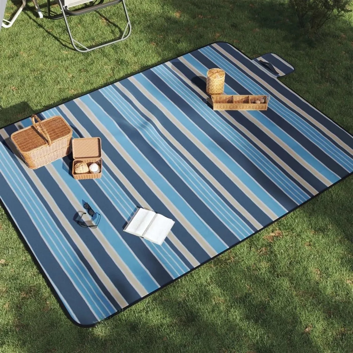 Gestreifte, blau-weiße Picknickdecke (200x150 cm) auf Rasen mit Picknickkorb und Buch.