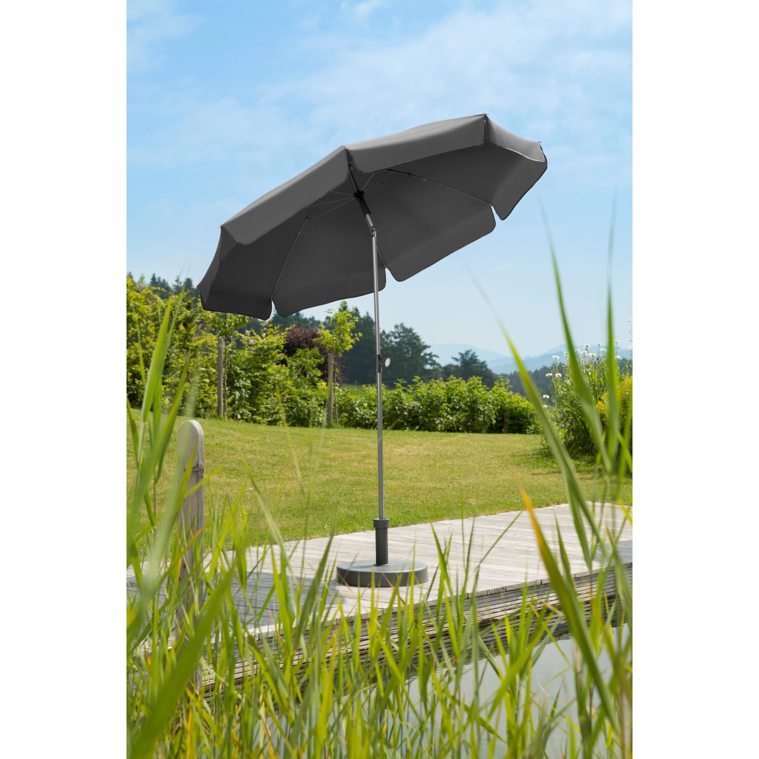Anthrazitfarbener Schneider Balkonschirm Locarno Ø 200 cm mit Push-Up Mechanik im Garten.