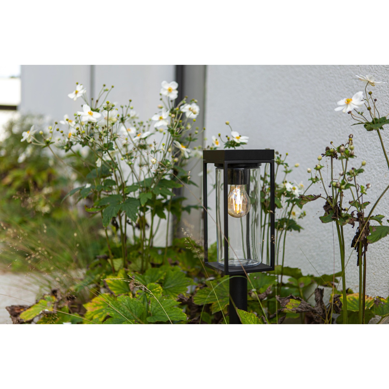 Lutec Flair Solar-Wegeleuchte, mattschwarz, mit Glaskörper und E27 Leuchtmittel im Garten.