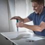 Mann sägt mit wolfcraft Handstichsäge für Gipskarton in eine Platte. Ergonomischer 2-K-Griff für präzise Schnitte.